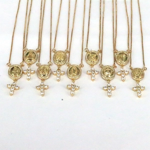 Detailed view of nine gold-plated religious necklaces with zircons and crosses