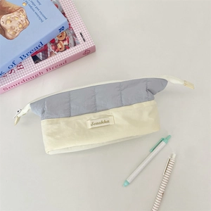 Close-up of quilted colorblock pencil case in blue and cream with Sozakka label