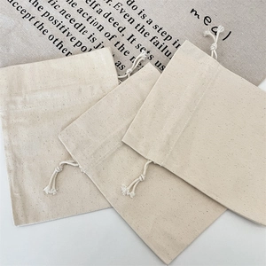 Macro detail of natural beige canvas drawstring bags showing high-density fabric texture