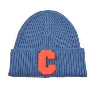 Detailed view of sky blue ribbed knit beanie featuring an orange letter C patch