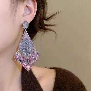 Ethnic geometric diamond drop earrings with vintage colorful mandala print on wooden pattern