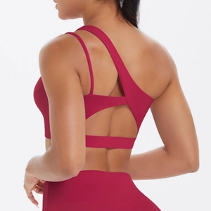 Detail of solid dark red sports bra featuring asymmetric strap and back cutout design