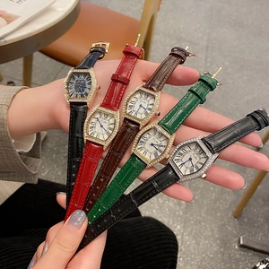 Macro detail of four leather strap watches in black, red, brown, and green with crystal bezel