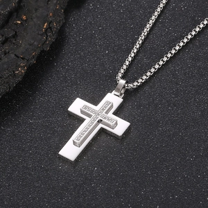Macro detail of silver stainless steel double layer cross pendant with zircon stones