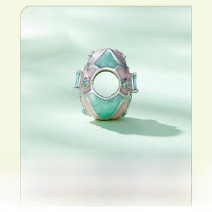 Macro shot of s925 silver Easter egg charm with pink and green enamel and blue crystals