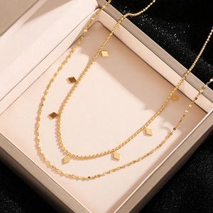 Detail of double-layer gold titanium necklace with rhombus pendants in a jewelry box