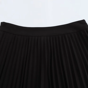 Detail of black pleated skirt waistband and fine synthetic fabric texture up close