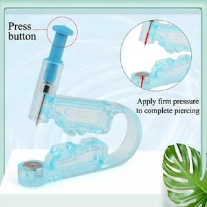 Blue disposable ear piercing gun tool with sterile needle on a decorative stand