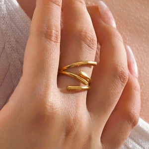 Minimalist gold spiral multi-layered wrap ring on female hand with modern sleek finish