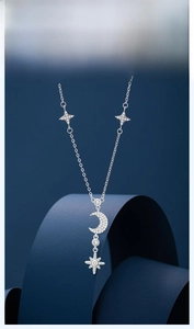 Detailed close-up of 925 silver crescent moon and star pendant necklace with zircons