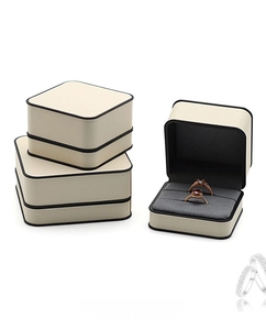 Detail view of cream jewelry box with grey velvet double slots and black line accents