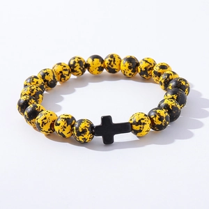 Close-up of yellow and black beaded bracelet with a central black cross charm