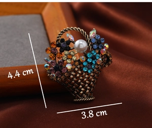 Close-up of vintage flower basket brooch with colorful rhinestones and white pearl detail