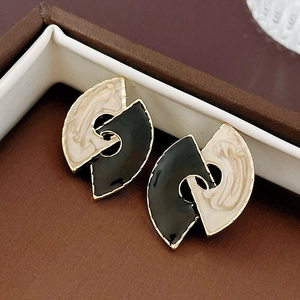Detail of geometric fan-shaped earrings with black and white marble enamel in gold finish