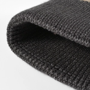 Dark grey knitted beanie with thick ribbed texture for winter warmth and comfort
