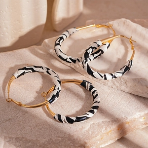 Gold-tone hoop earrings with black and white zebra pattern leather wrap detail