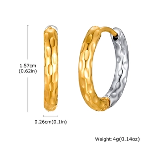 Détail de boucles d'oreilles géométriques avec finition bicolore et texture martelée