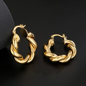 Vintage chunky twisted geometric hoop earrings with gold plating on black background