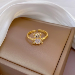 Close-up of gold bear ring with heart-shaped crystal on a premium silk display