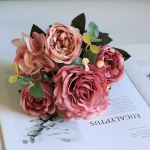 Overhead view of silk rose bouquet with pink petals on an open botanical magazine