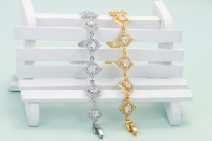 Elegant gold and silver bangles with geometric diamond accents on a mini white bench