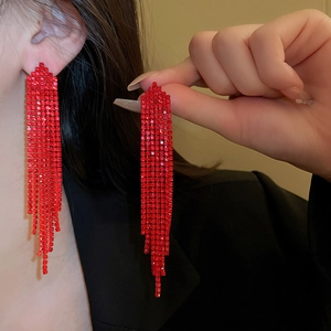 Close-up of vibrant red rhinestone tassel earrings showing intricate hanging chain details