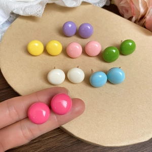 Close-up of colorful round stud earrings set in candy colors on a decorative card
