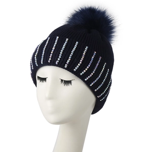 Women's dark blue knit beanie with colorful rhinestones and a large faux fur pom-pom