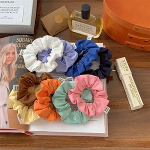 Set of 8 colorful vintage scrunchies displayed with minimalist lifestyle accessories
