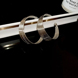 Macro shot of silver layered hoop earrings in geometric design on a white prop