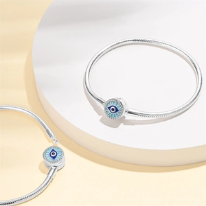 Silver snake chain bracelet featuring blue evil eye charms with sparkling crystals