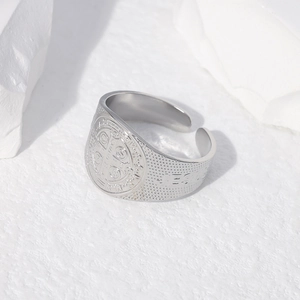 Macro view of St. Benedict Medal cross pattern on vintage stainless steel ring