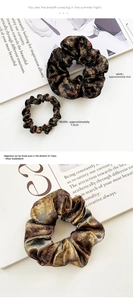 Detailed comparison of large 4cm and small 1.5cm leopard print scrunchies in glossy fabric