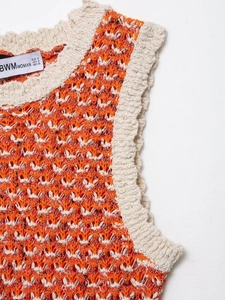 Close-up of contrast knit texture and collar seam on an orange-white crochet mini dress