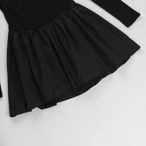 Detail of black knit bodice stitching and ruffled hem on an off-shoulder A-line mini dress