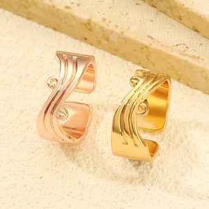 Macro view of gold and rose gold plated open rings with ornate wave and vine carvings