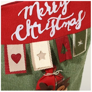 Vue macro d'une chaussette de Noël en tricot avec renne et écussons en feutre cousus main