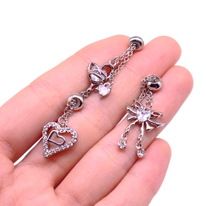 Macro detail of silver heart and bow nipple rings with sparkling cubic zirconia stones