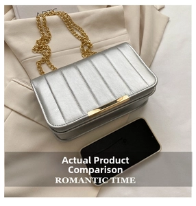 Silver quilted shoulder bag with gold chain strap shown next to a smartphone for size
