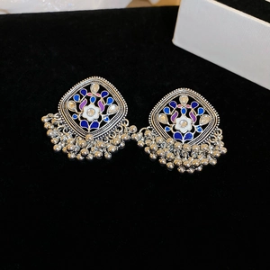 Detailed close-up of ethnic Jhumka earrings with blue enamel and silver beads
