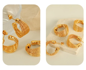 Detail von mehrlagigen goldenen Creolen mit strukturierter Spiralform und metallischem Glanz