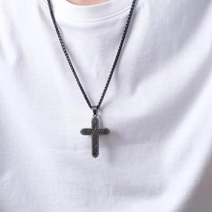 Pendentif croix bicolore en acier inoxydable pour hommes porté par un modèle sur t-shirt