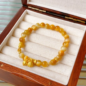 Elegante kralenarmband met gele kattenoogstenen en gouden lotusbloem hangertjes