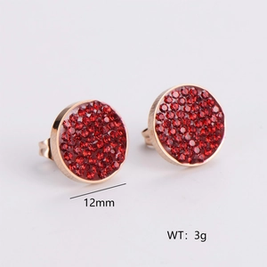 Detail view of 12mm round gold earrings with red faceted crystals weighing 3g