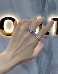 Close-up of S925 silver rings with emerald cut purple and yellow gems and pavé stones