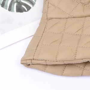 Detail shot of khaki quilted bucket hat featuring nylon fabric and warm padding
