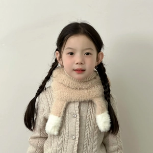 Détail d'une écharpe en peluche kaki avec pompons blancs pour enfant en hiver