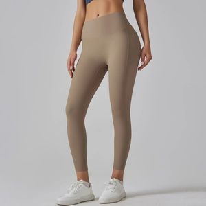 Close-up of high-waisted khaki yoga leggings with functional side pockets and wide waistband