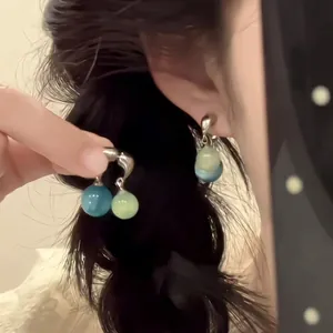 Detailed view of blue and green crystal bead earrings worn with vintage Chinese style