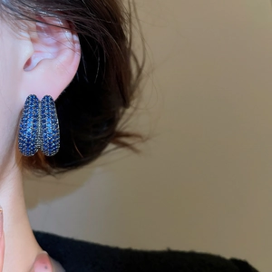 Close-up of model wearing navy blue zircon double-layered U-shaped hoop earrings
